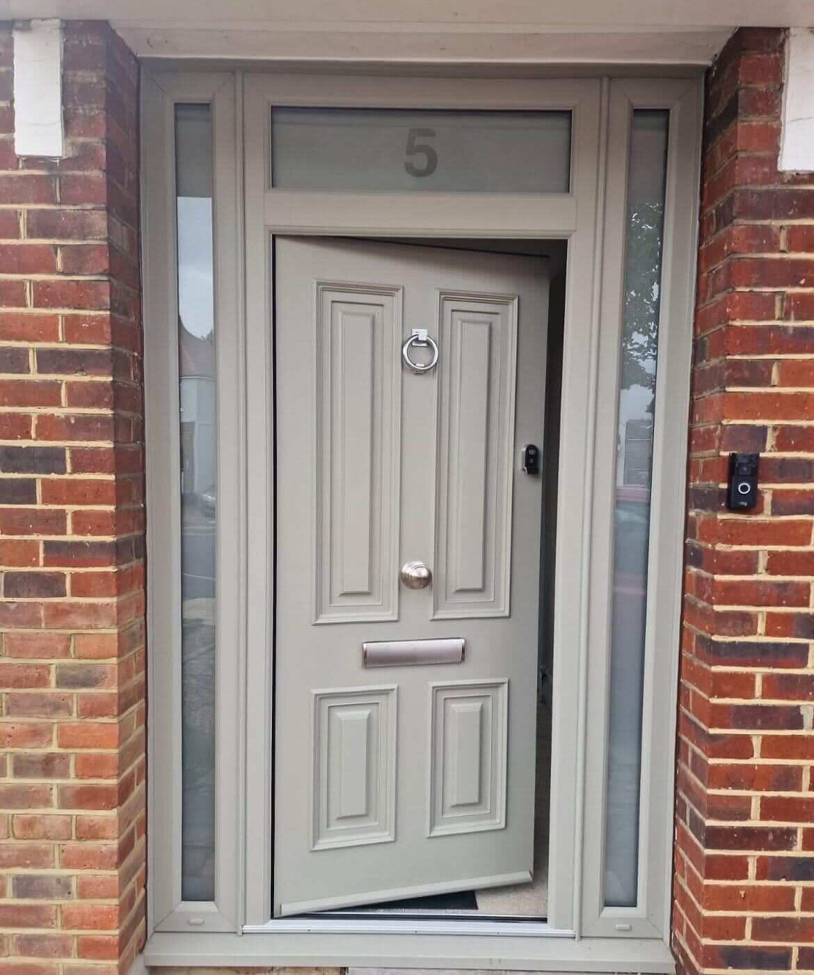 Stone-coloured panelled composite front door with sidelights and fanlight