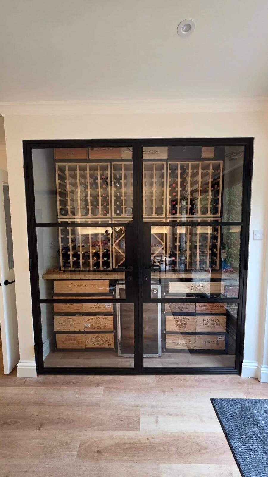 Black Crittall-style internal double doors to a wine room