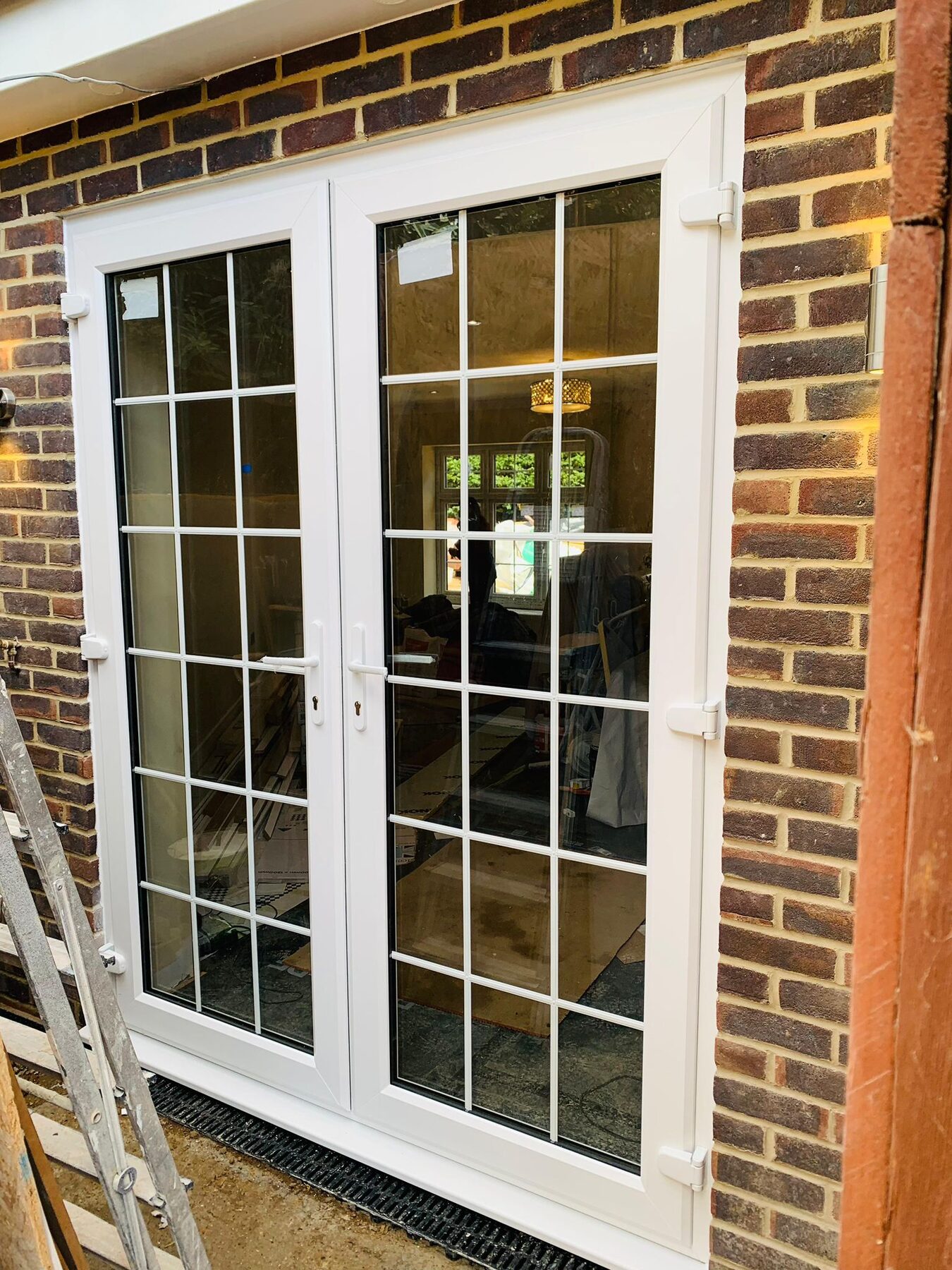 White uPVC French doors with Georgian bars in a brick opening