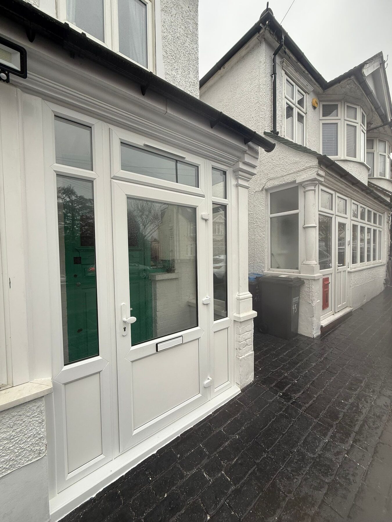 White uPVC entrance door with glazed side panels and transom